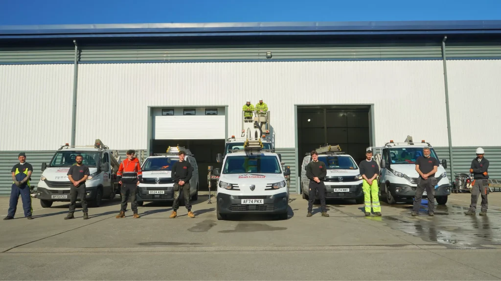 Photo of staff and vehicles in front of the workshop.